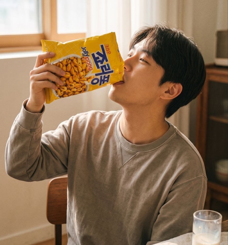 A man tipping a Jolly Pong bag to his mouth